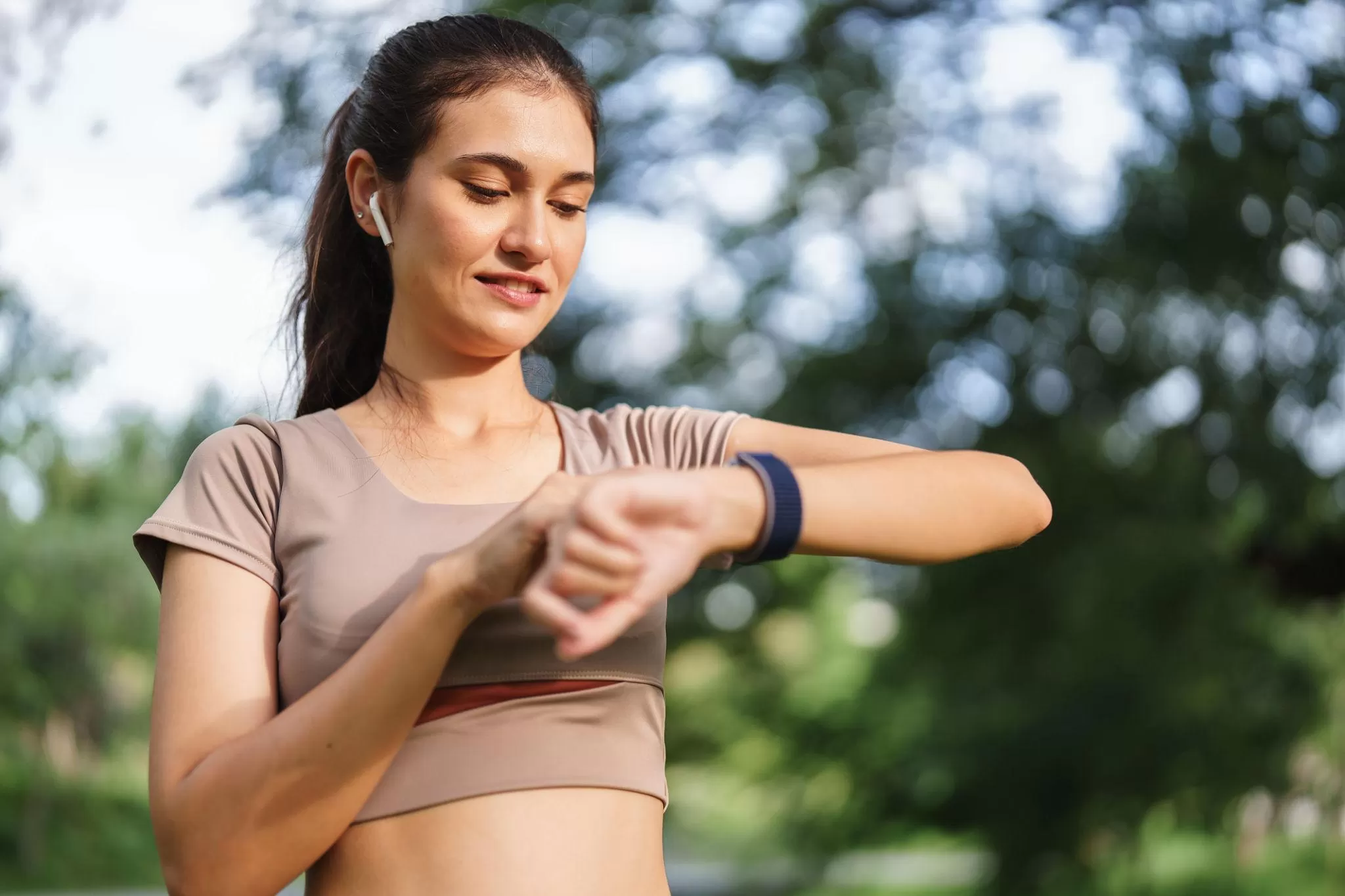 Woman checking fitness statistics on her smartwatch during a calm morning routine, with soft natural light illuminating the scene